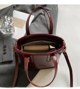 Interior view of wine red leather bucket bag showing compartments for phone and lipstick