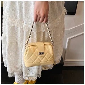Détail du sac bandoulière matelassé crème avec chaîne argentée et fermoir pivotant