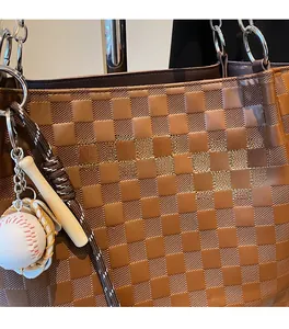 Close-up of brown checkered tote bag with fashion leather patch and baseball charm