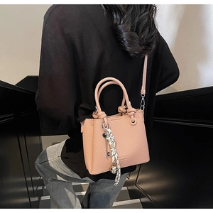Detail view of pink lychee leather tote bag with silk scarf and gold ring handles