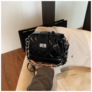 Détail du sac à bandoulière en cuir verni noir matelassé avec fermoir argenté et chaîne
