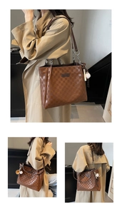 Close-up of brown checkered tote bag with leather strap and baseball charm detail