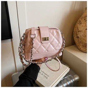 Gros plan détaillé du sac matelassé rose avec chaîne argentée et fermoir rotatif