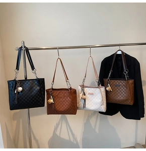 Detail of checkered tote bags with metal chain straps and ball pendant accessories