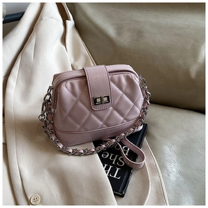 Détail du sac à bandoulière rose matelassé avec fermoir rotatif et bandoulière chaîne