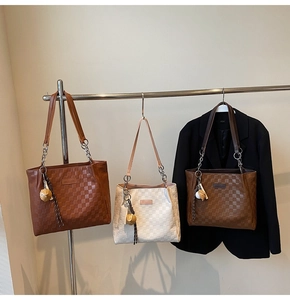 Detailed view of checkered embossed tote bags in dark brown, cream, and tan colors