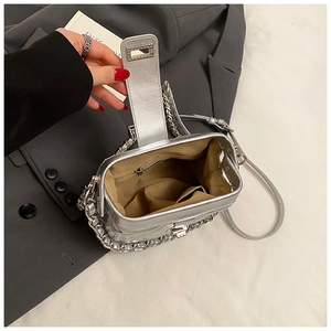 Détail du sac à bandoulière argenté avec chaîne, fermoir en métal et doublure intérieure