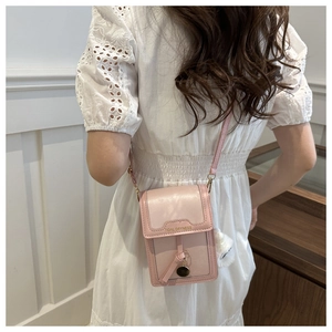 Dettaglio della borsa rosa con scritta Tidal Dryness e ciondolo a forma di palla di peluche