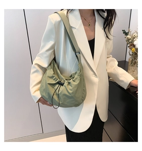 Grey-green pleated drawstring shoulder bag shown on model for stylish daily commuting