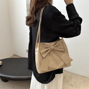 Sac cabas beige minimaliste avec grand nœud porté à l'épaule pour un style chic et élégant