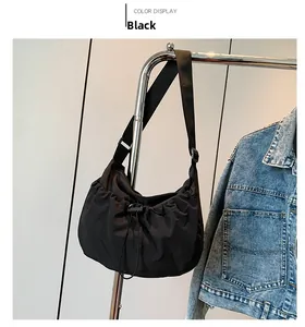 Close-up of black nylon crescent bag with pleated texture and adjustable shoulder strap