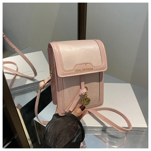 Dettaglio della borsa a tracolla in pelle PU rosa chiaro con nappina e fibbia dorata