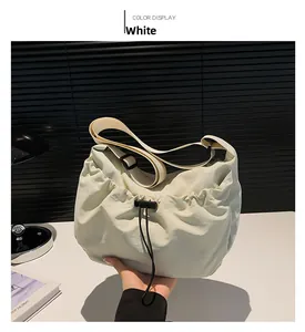 Detail of white nylon crossbody bag featuring a drawstring closure and adjustable strap