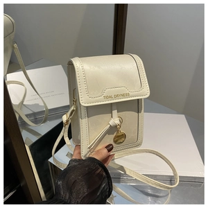 Dettaglio mini borsa crema con logo Tidal Dryness dorato e ciondolo con nappina