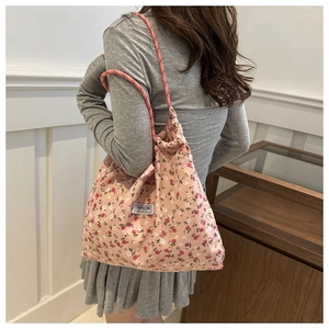 Detail of pink floral nylon tote with rope straps and Fashion Instinct label tag