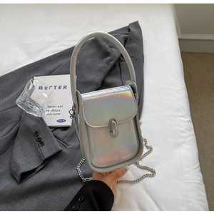 Close-up of holographic silver crossbody bag with metallic chain and stylish cylinder lock