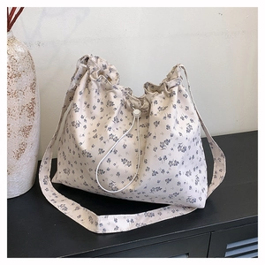 Détail du sac cabas en toile à fleurs avec cordon de serrage et motifs bleus