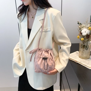 Pink nylon drawstring bucket bag with pleated texture and adjustable strap for women
