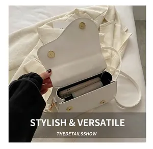 Interior view showing capacity of a white faux leather saddle bag with magnetic closure