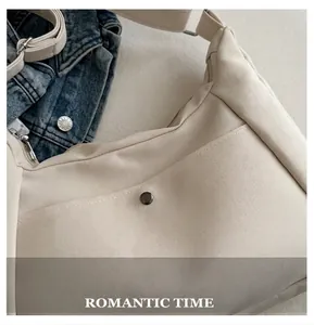 Close-up of cream canvas hobo bag showing diagonal twill texture and vintage metal button
