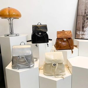 Fashion PU leather backpacks in silver, black, brown and white on creative display stands