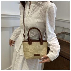 Détail du sac panier en paille avec anses en cuir marron et bandoulière fine