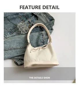 Detail of herringbone fabric and leather shoulder bag with chic bow accent decoration