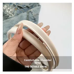 Detailed macro view of cream-colored shoulder straps with reinforced stitching and soft texture
