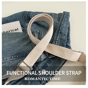 Detail of adjustable thick canvas shoulder strap with silver metal buckle on denim