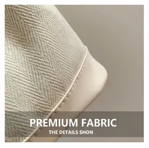 Detail of high-quality woven herringbone fabric and smooth beige leather stitching