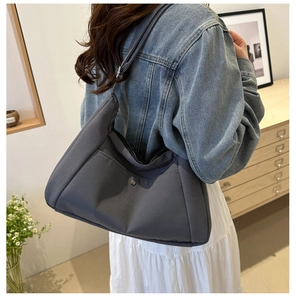 Détail d'un sac fourre-tout en nylon gris foncé avec poche et bandoulière réglable