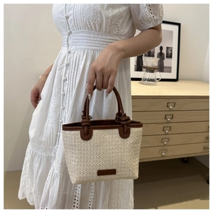 Detail of hand-woven straw tote with premium brown leather trim and handles for vacation