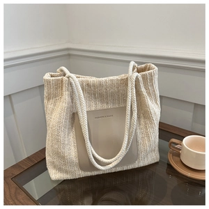 Detail of hand-woven tote bag with leather patch and thick cotton rope handle