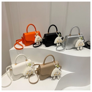 Five assorted mini crossbody bags with wave-edge flaps and cute plush charms on display