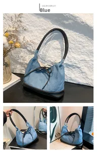 Close-up of blue denim tote bag with black bow detail and contrasting leather handles
