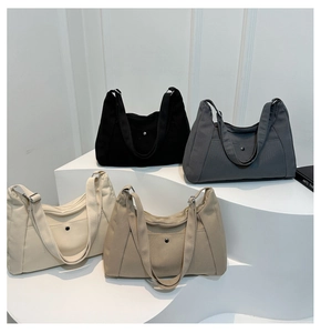 Selection of canvas tote bags in black, gray, cream, and khaki on a white tiered display