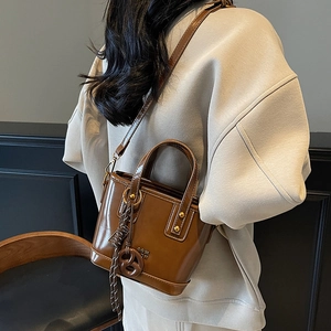 Retro brown glossy leather bucket bag with top handle and adjustable crossbody strap