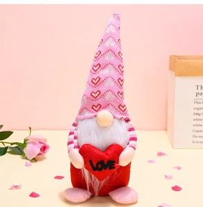 Close-up of pink Valentine's gnome plush holding a red Love heart with rose decoration