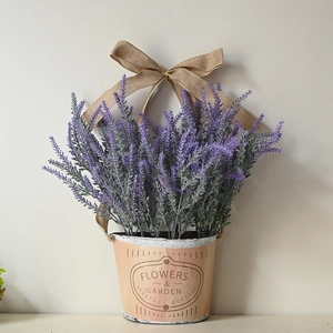 Gros plan de fleurs de lavande dans un seau en métal rose avec un nœud en toile