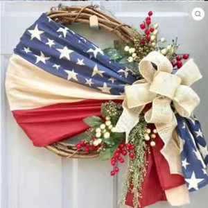 Detail of USA Independence Day wreath featuring burlap bow and patriotic ribbons on grapevine