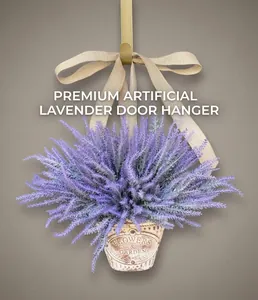 Détail d'une couronne de lavande en panier métal avec nœud en lin sur porte foncée