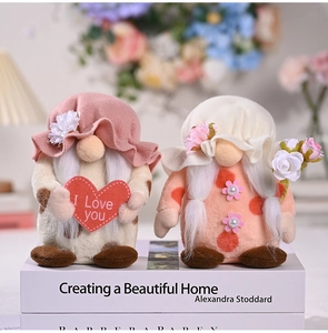 Detail of two Mother's Day gnomes holding a heart and flowers on books in cozy setting