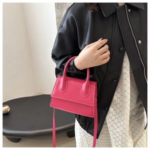 Detail showing high-gloss magenta faux leather texture on a structured mini handbag