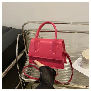 Detail of rose red leather crossbody bag with top handle and adjustable strap