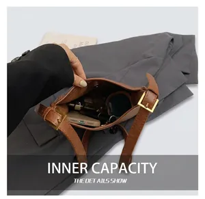 Internal capacity of the brown leather handbag showing phone and lipstick storage