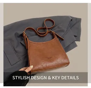 Close-up of brown vintage leather shoulder bag with adjustable strap and bronze hardware