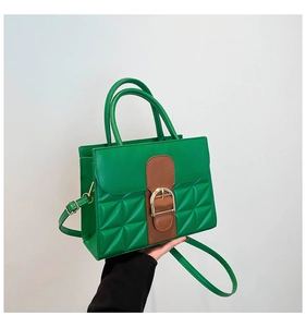 Détail du sac bandoulière vert et marron avec motifs matelassés et fermoir doré chic