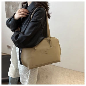 Detail view of khaki leather tote bag featuring fashion embossed pocket and gold hardware