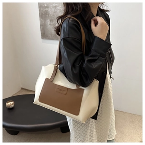 Détail d'un grand sac cabas bicolore beige et marron avec poche extérieure et bandoulière