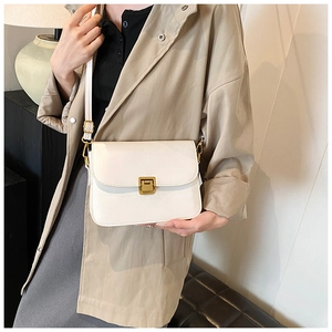 Detail of minimalist white crossbody bag with gold buckle on trench coat model